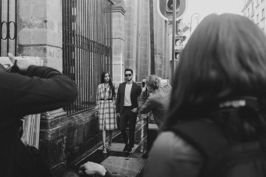 photojournalists photographing couple models on street