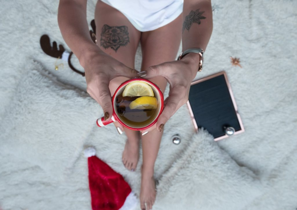 person holding cup filled with brown liquid