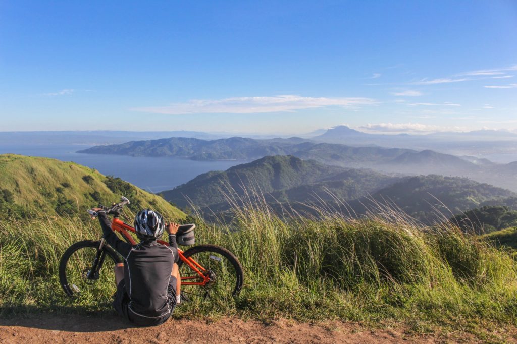 man sitting beside bicycle