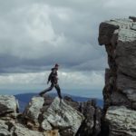 man walking on rock formations