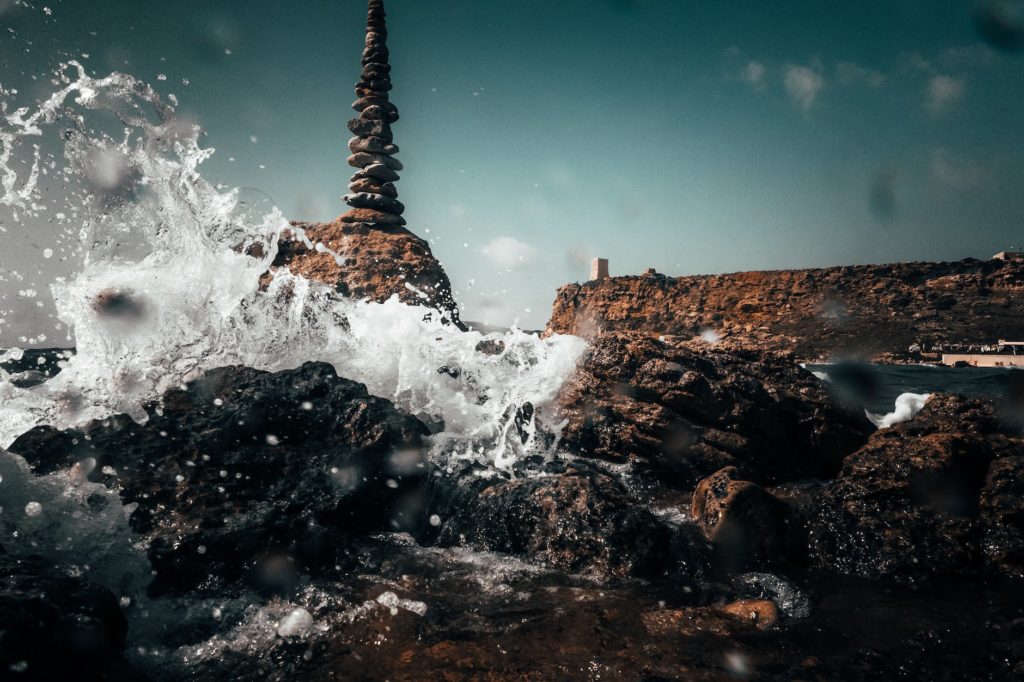 ocean water splashing on rocks