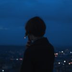 person smoking across city building during nighttime