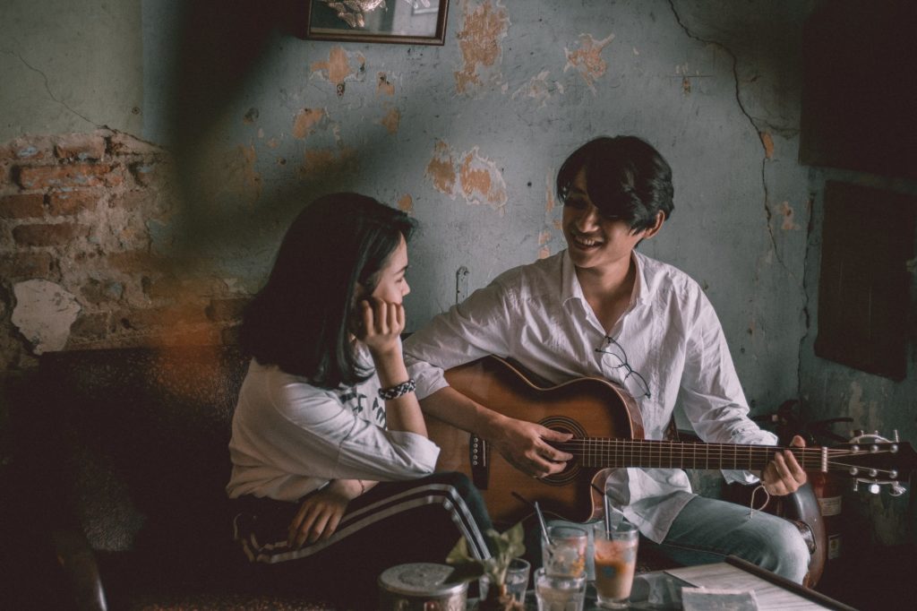 man playing guitar with girl