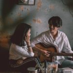 man playing guitar with girl