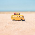 yellow die cast miniature van on brown sand