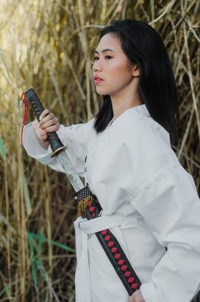 woman in white long sleeve clothing holding a sword