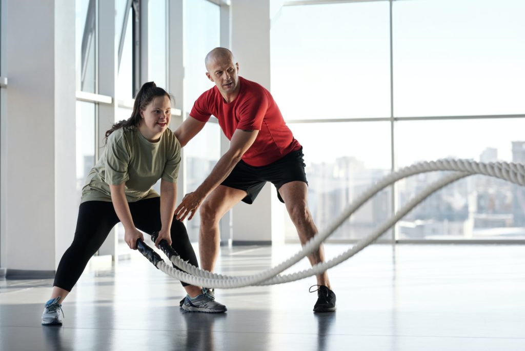 a woman holding ropes beside a trainer