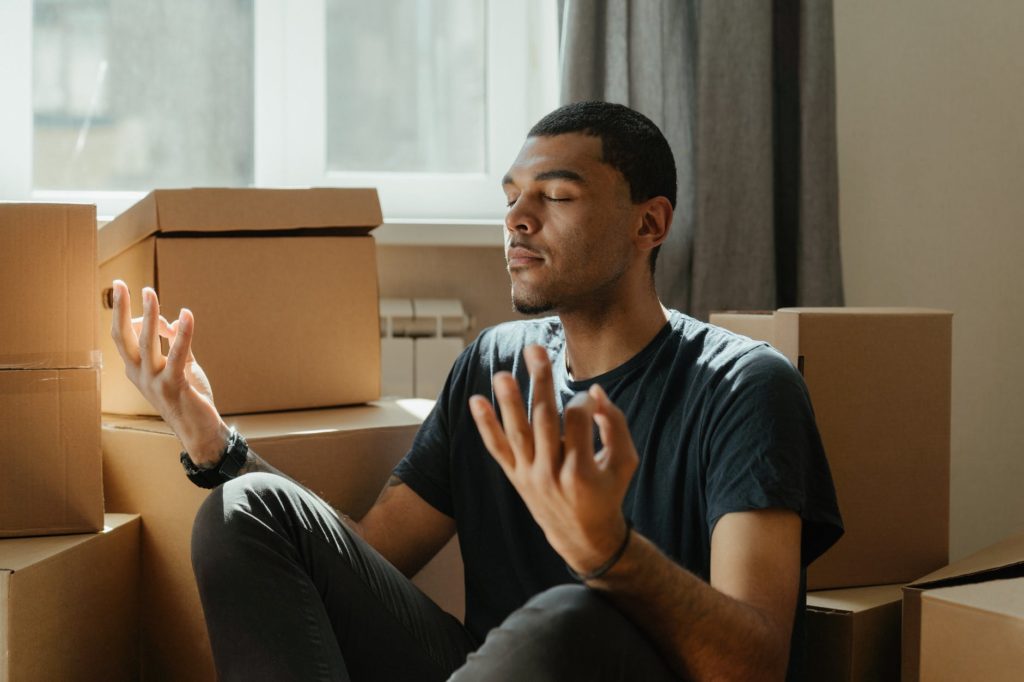 man in black crew neck t shirt sitting on brown sofa