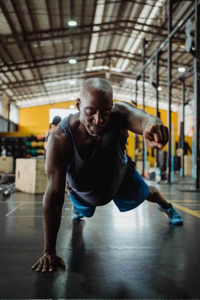 man in gray tank top and blue shorts doing push up