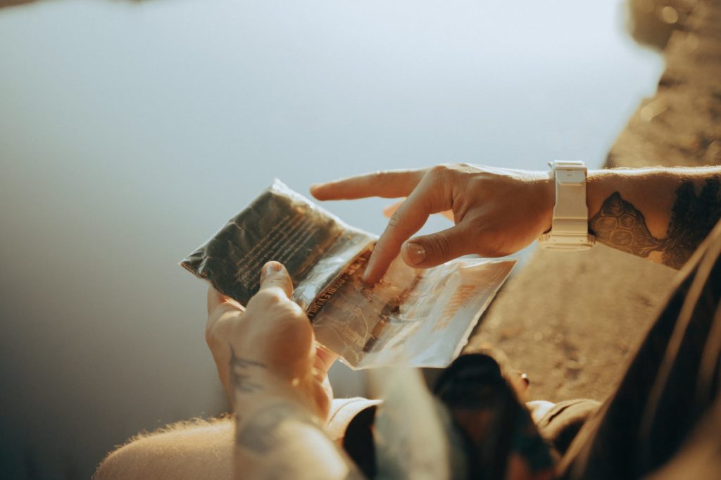 person holding a plastic bag with tobacco