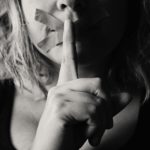 woman placing her finger between her lips