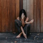 female sitting gracefully on wooden floor