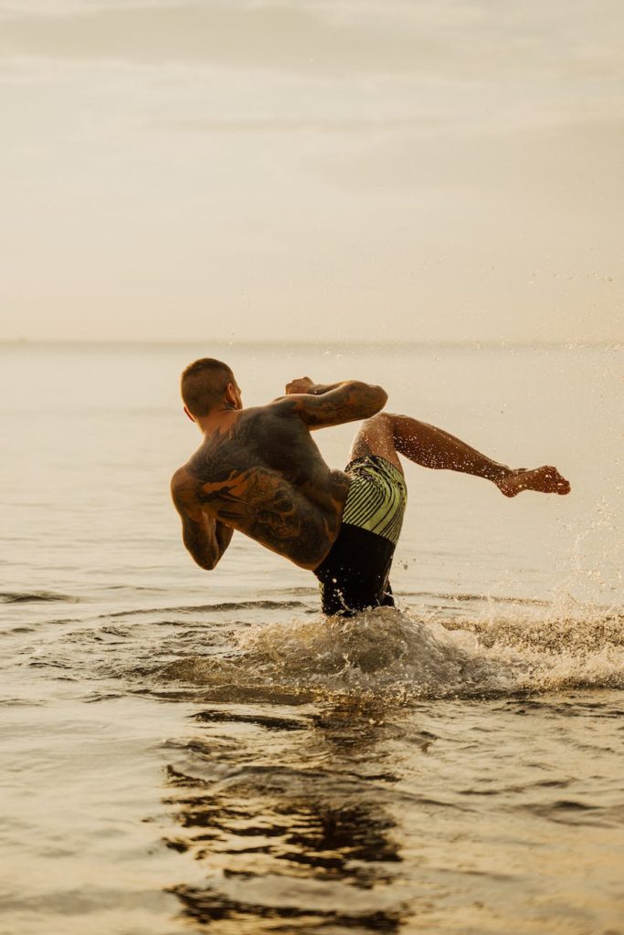 a man practicing kick boxing while on the beach