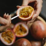 female enjoying pulp of passion fruit