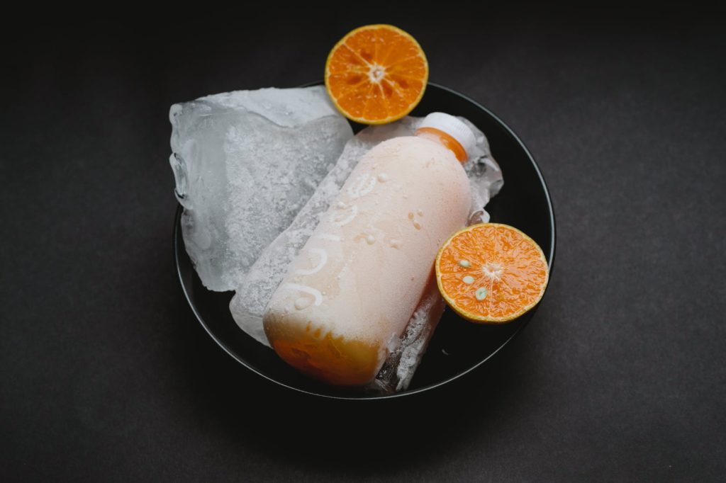 bottle with orange juice on plate