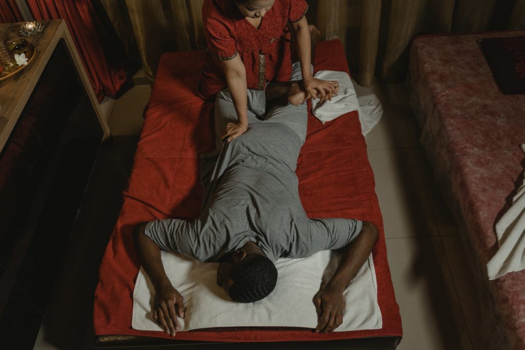 woman in red shirt making thai massage