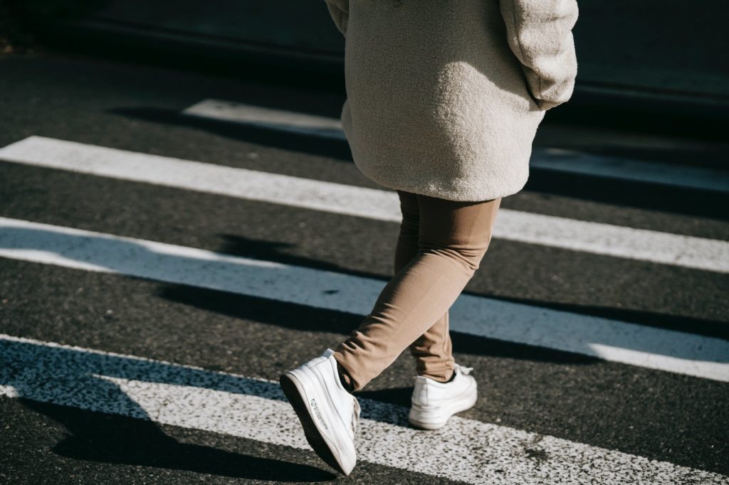 crop faceless woman walking on zebra