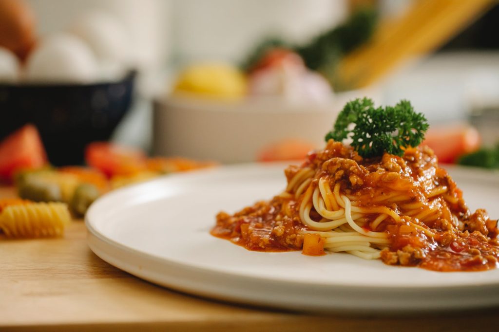 appetizing spaghetti pasta with bolognese sauce served in kitchen