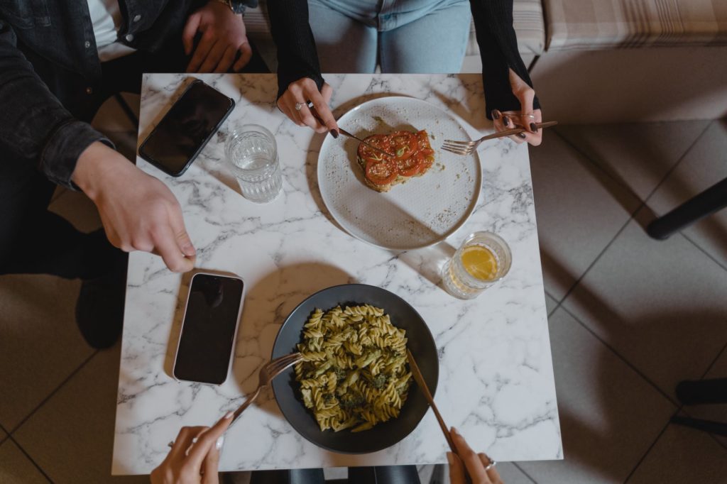 people holding a fork and knife on the table with vegan food