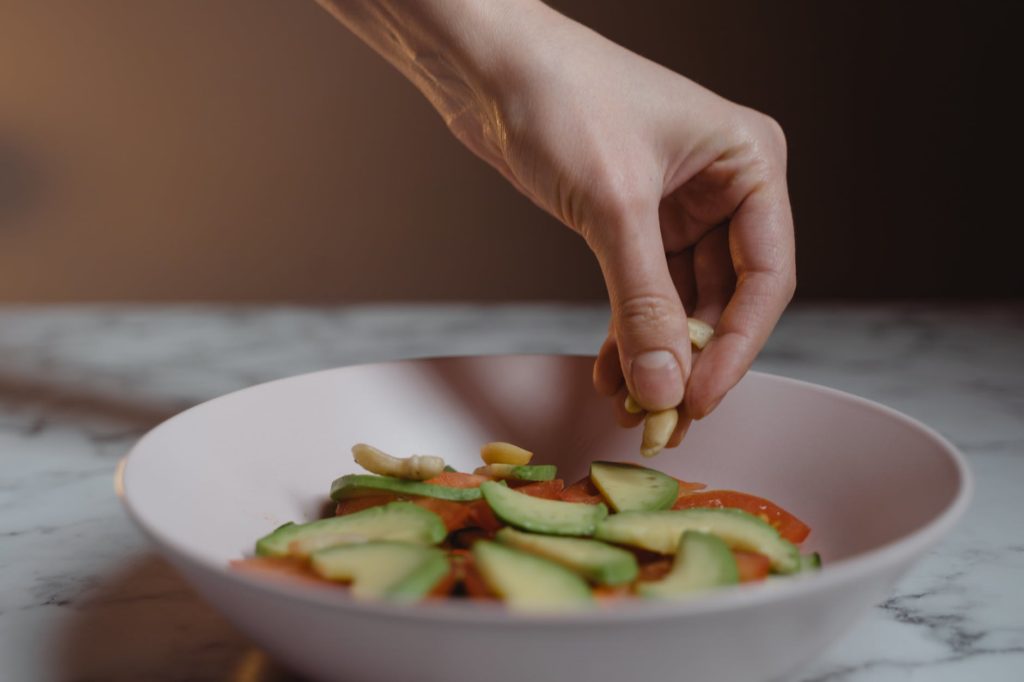 a person putting nuts on a ceramic bowl