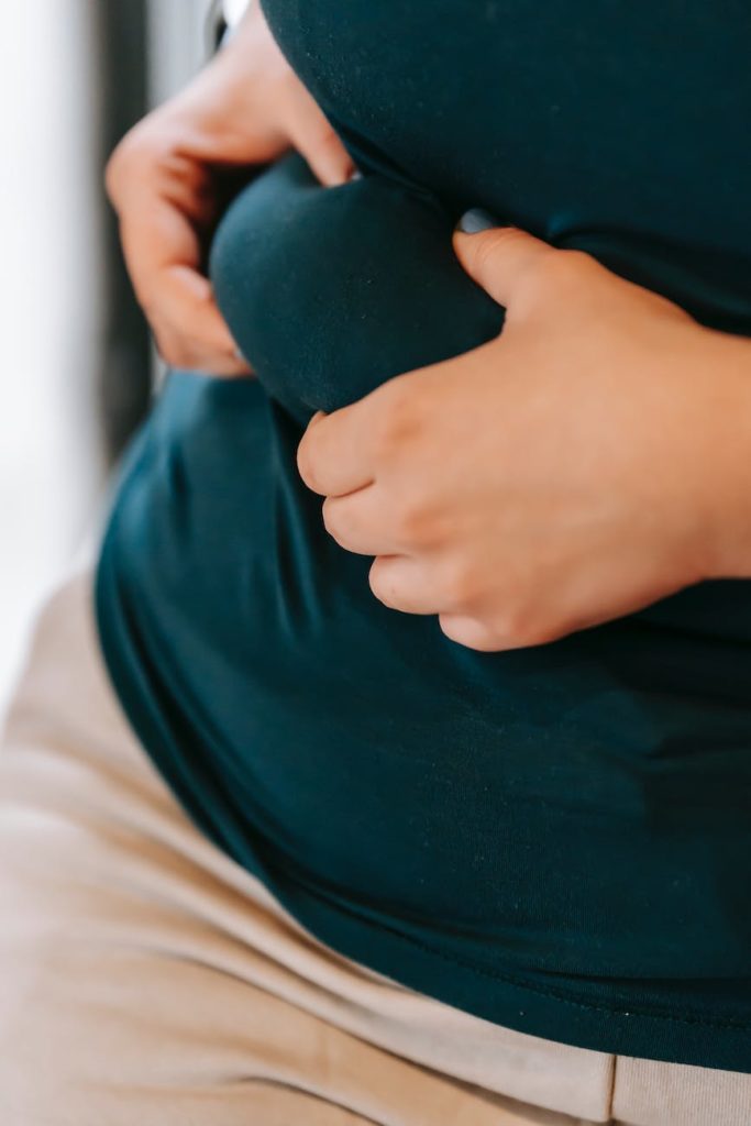 crop plump woman touching abdomen