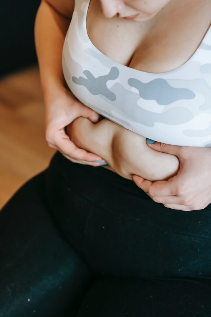 anonymous overweight woman touching tummy during training