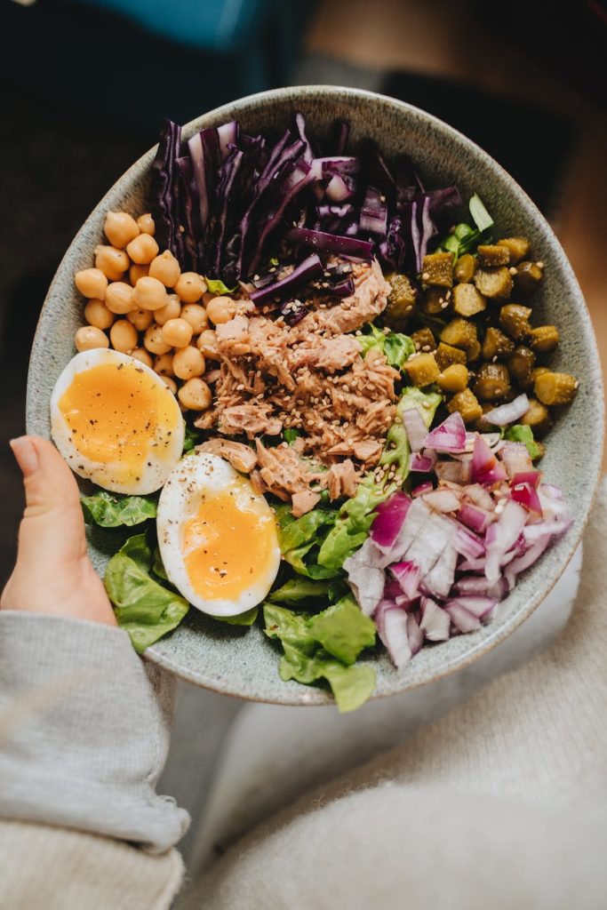 photo of a person holding a bowl with a healthy meal