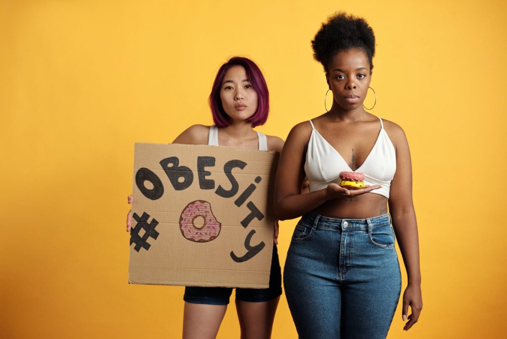 serious face women holding donuts and a cardboard