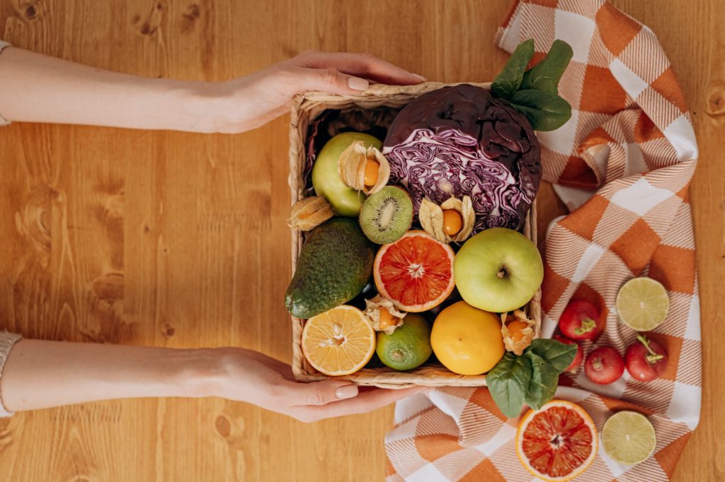 person holding a basket of fruits