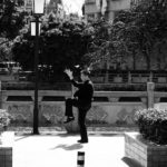 black and white photo of a man exercising tai chi in a city