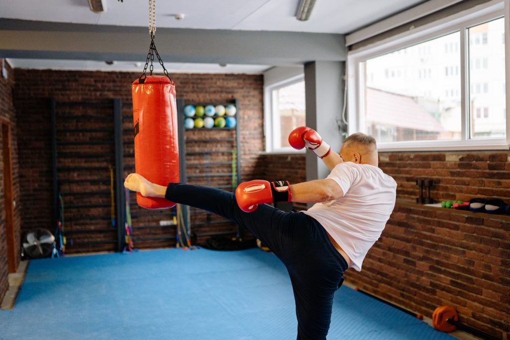 a man kicking a heavy bag