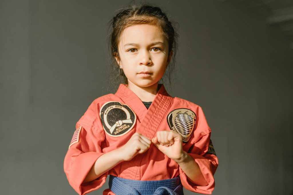 close up shot of a girl wearing red dobok and blue belt