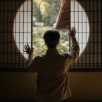 man looking through round window