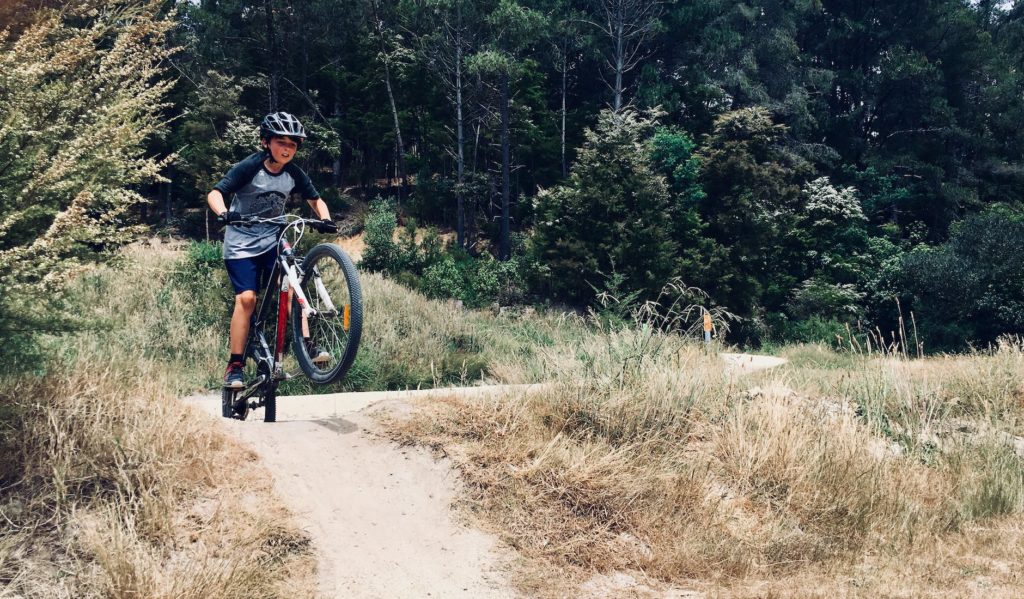 photo of boy riding a bike