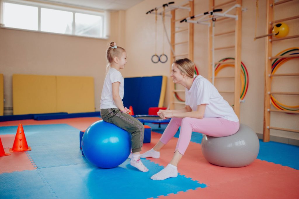 a mother and daughter sitting on exercise balls