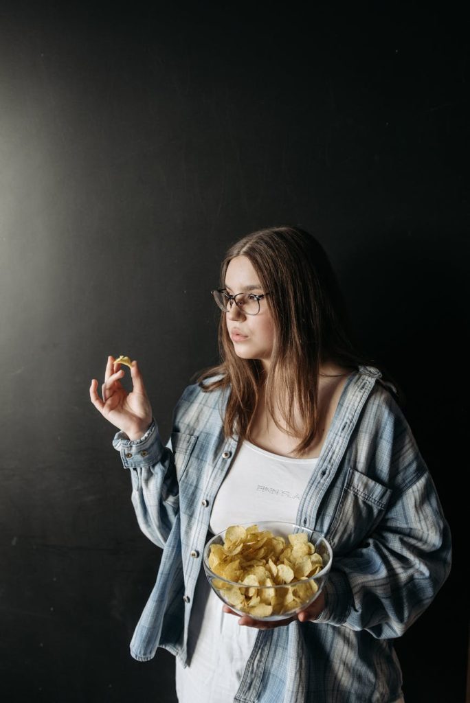 a woman eating a bowl of chips