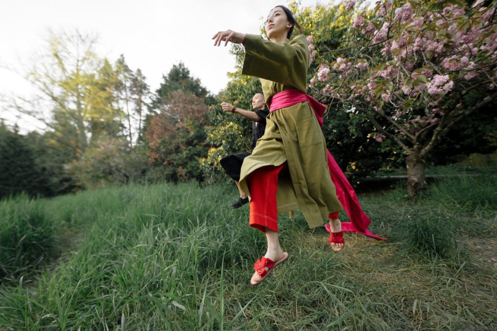 girl in green and red dress standing on green grass field