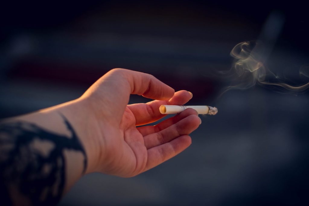 close up photography of a person holding cigarette