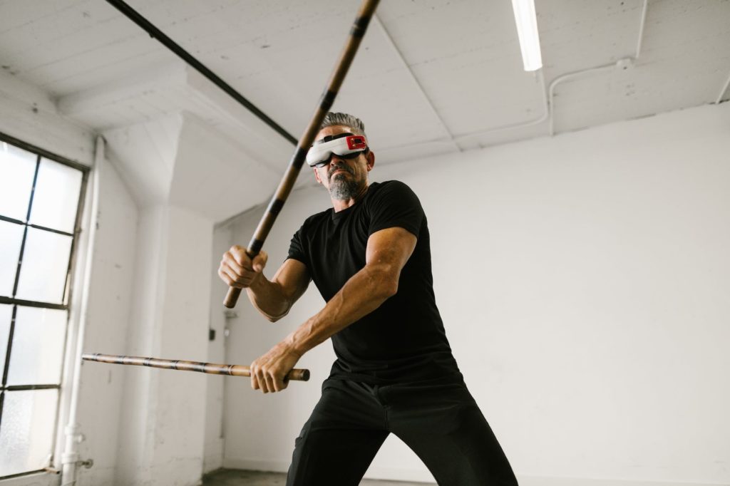 man using an arnis while wearing virtual reality glasses