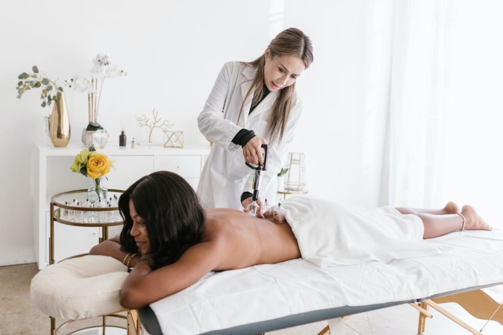 a shirtless woman getting an acupuncture