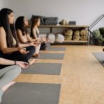 a man instructing yoga to a group of women