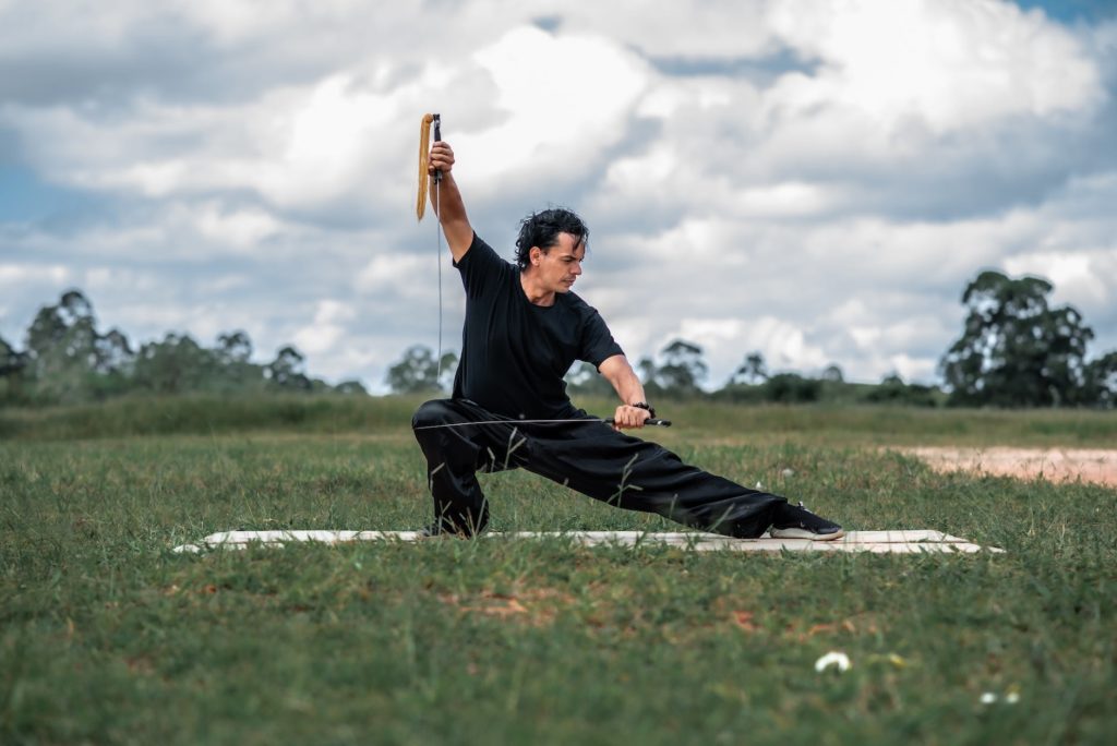 man posing with swords