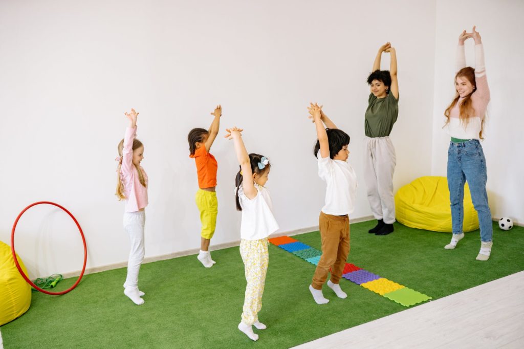 children with teachers doing stretching exercise