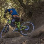 man in black and orange bicycle riding jacket with green off road bike