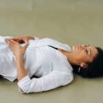 woman in white long sleeve shirt lying on floor