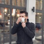 young man in medical mask on urban street during coronavirus pandemic