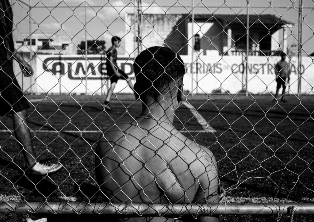 man behind a fence in black and white