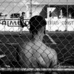 man behind a fence in black and white