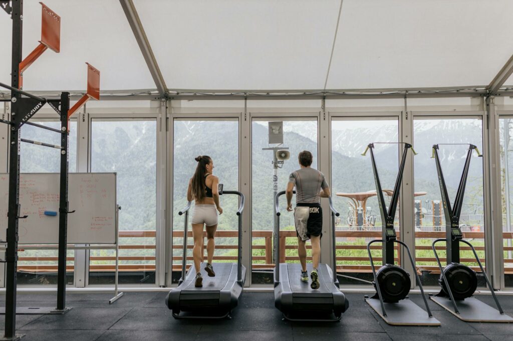 man and woman exercising on a treadmill at the gym